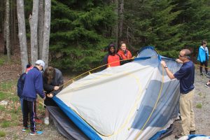 Students and leaders working together to set up a tent