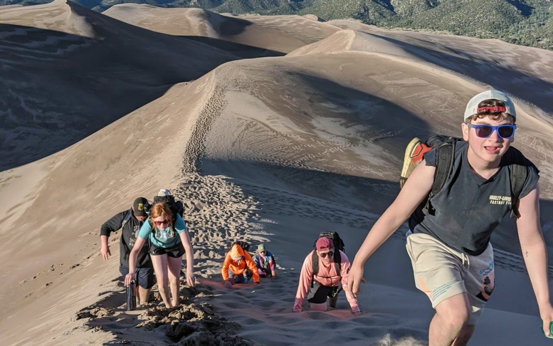 Students hiking sand dunes.