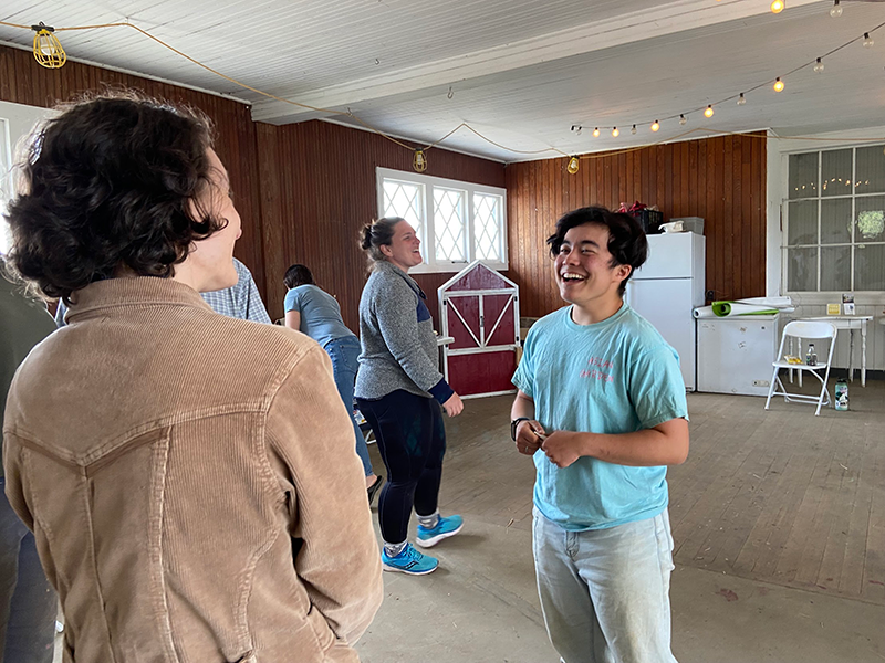 Two workshop participants engage in an activity. One person in a blue shirt is smiling.